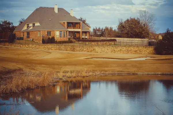 Two-story brick home overlooking a pond in Carrollton, Texas