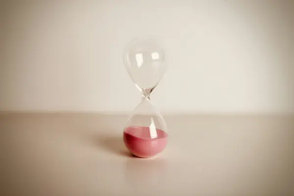 Hourglass with red sand running out, symbolizing the short Texas foreclosure timeline